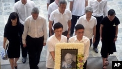 FILE - In this Sunday, March 29, 2015, file photo, the family members second row left to right; Lee Suet Fern, son Lee Hsien Yang, son Lee Hsien Loong, Ho Ching and Lee Wei Ling, daughter of the late Lee Kuan Yew, arrive with his portrait at the start of the state funeral. 