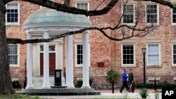 FILE - Students remove belongings on campus at the University of North Carolina in Chapel Hill, N.C., March 18, 2020.
