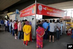People stand in a queue to get tested for the coronavirus, in Ahmedabad, India, April 9, 2021.