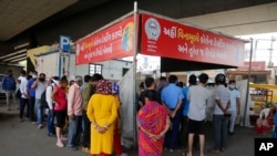 People stand in a queue to get tested for the coronavirus, in Ahmedabad, India, April 9, 2021.