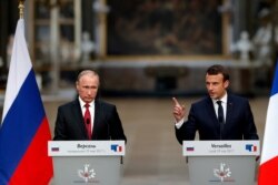 FILE - French President Emmanuel Macron (R) and Russian President Vladimir Putin are seen at a joint press conference in Versailles, France, May 29, 2017.