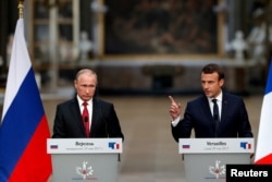 FILE - French President Emmanuel Macron (R) and Russian President Vladimir Putin are seen at a joint press conference in Versailles, France, May 29, 2017.