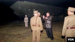 Pemimpin Korea Utara Kim Jong Un dan pejabat militer berdiri di samping kendaraan peluncur rudal bergerak dalam gambar tidak bertanggal yang ditampilkan dalam video yang dirilis pada 1 November 2024. (Foto: KRT/via Reuters)