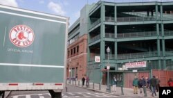 The tail end of the Red Sox team equipment truck crosses Yawkey Way outside Fenway Park, Feb. 5, 2018, in Boston. The truck was headed to the team's spring training facility in Fort Myers, Florida.