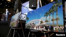 Los Angeles Rams Chief Operating Officer Kevin Demoff speaks behind an illustration of the Rams' planned new stadium at a celebration to welcome NFL team, the Los Angeles Rams, at the Forum in Inglewood, California, Jan. 15, 2016.