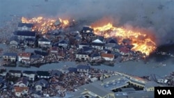 Rumah-rumah terbakar sementara sungai Natori meluap setelah tsunami melanda kota Natori, provinsi Miyagi, Jepang timur laut, Jumat (11/3).