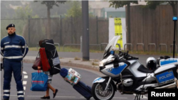 En la imagen, una mujer con pertenencias pasa junto a un policía durante la evacuación de unas 60.000 personas en Fráncfort, el 3 de septiembre de 2017.