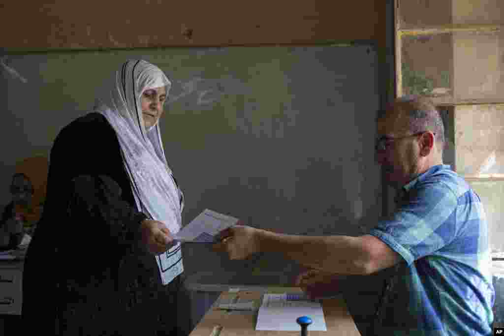 A woman receive a voting bill at a polling station as Kurds vote for independence in the disputed city of Kirkuk, Sept. 25, 2017. Iraq's Kurdish region vote in a referendum on whether to secede from Iraq. 