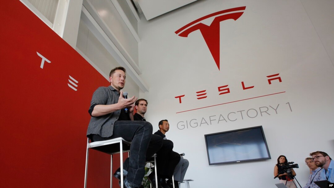FILE - Elon Musk, CEO of Tesla Motors Inc., left, discusses the company's new Gigafactory in Sparks, Nevada, July 26, 2016. Tesla announced in September that it had been selected to build a battery storage project at the Mira Loma electricity substation i