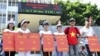 Students hold placards in a protest against a gasoline price hike in front of Petrolimex, in Hanoi, September 16, 2012.