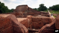 FILE - Tourists walk at the ruins of the Nalanda University at Nalanda, India, July 5, 2006. 