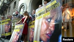 FILE - PETA (People for the Ethical Treatment of Animals) protestors hold banners depicting Italian designer Donatella Versace in front of the Versace store in Milan, Italy.