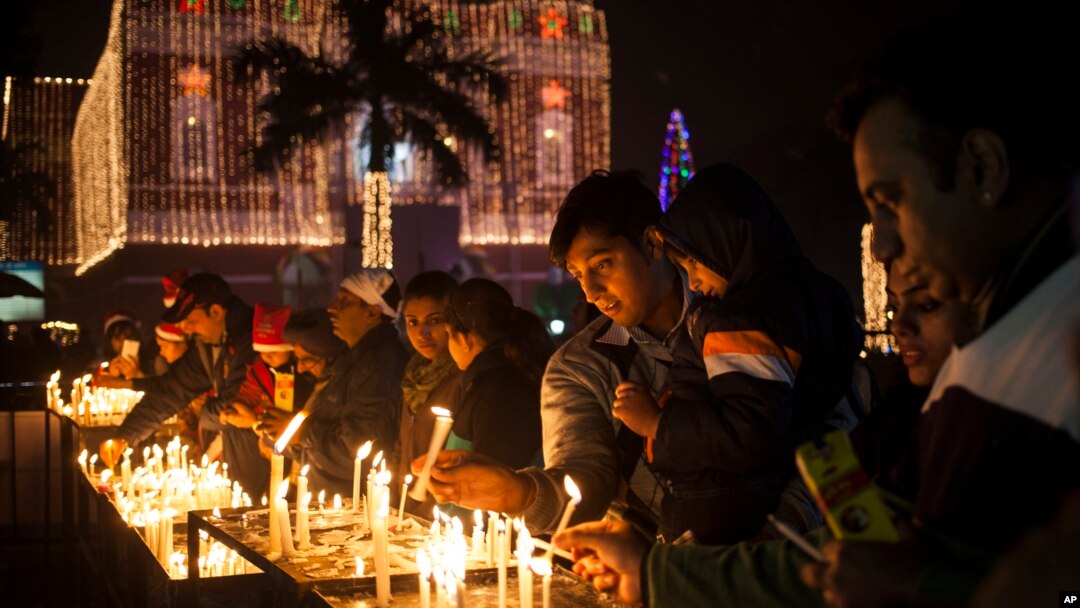 FILE - Indian Christians light candles at a Sacred Heart Cathedral on the eve of Christmas in New Delhi, India, Wednesday, Dec. 24, 2014.