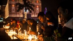 FILE - Indian Christians light candles at a Sacred Heart Cathedral on the eve of Christmas in New Delhi, India, Wednesday, Dec. 24, 2014.