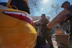 Members of the U.S. Army National Guard distribute boxes of free food provided by multiple New York City agencies, during the outbreak of the coronavirus disease in the Harlem neighborhood of Manhattan in New York City, April 15, 2020.
