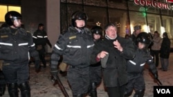 Polisi anti huru-hara menangkap seorang demonstran di Minsk, Belarusia.