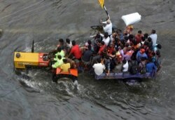 People are rescued in a tractor from a flooded area following heavy rainfall in Patna, India, ept.30, 2019.