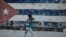 In this file photo taken on June 22, 2021 a woman walks near a wall depicting the Cuban flag in Havana. (Photo: AFP)