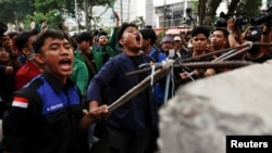 University students shout as they attempt to pull down the barricade during an anti-government protest called 'Indonesia Gelap' (Dark Indonesia) against the recent budget efficiency policies, near the presidential palace in Jakarta, Feb. 20, 2025. 