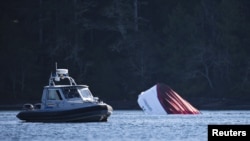 Un bote de la Policía canadiense lleva buzos hasta el lugar donde se hundió el domingo un barco crucero en Tofino, en la Columbia Británica.