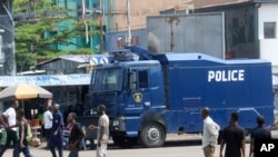 Warga berjalan melewati truk polisi di Kinshasa, Kongo, 19 Desember 2016. (Foto: dok). Pihak berwenang di bagian timur laut Kongo mengatakan pemberontak Uganda telah membunuh lebih dari 20 orang dengan parang pada hari Natal lalu. 