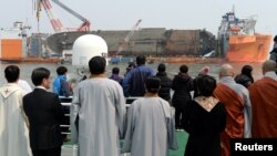 Para anggota keluarga korban tenggelamnya kapal Sewol mengamati upacara pengangkatan lkapal tersebut dari dasat laut Jindo, Korea Selatan, 28 Maret 2017 (Foto: Yonhap via Reuters). 