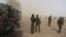 FILE - Cameroonian soldiers stand guard amidst dust kicked up by a helicopter in Kolofata, Cameroon, March 16, 2016. Part of a multinational force, the soldiers have intensified their fight against Boko Haram militants.