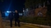 Plainclothes police officers pass by a primary school following a knife attack that occurred on an intersection road near a school in the northwestern Haidian district in Beijing, Oct. 28, 2024.