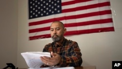 ARCHIVO - El migrante chino Li Kai, también conocido como Khaled, un musulmán étnico hui, estudia para obtener una licencia de conducir comercial en su apartamento en Flushing, Nueva York, el 3 de mayo de 2024.