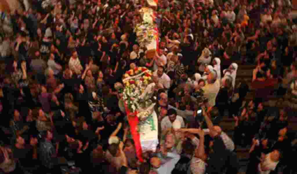 Mourners carry the coffins of slain Christians during their funeral in Baghdad, Iraq, Tuesday, Nov. 2, 2010. The victims were killed Sunday when gunmen stormed a church during mass and took the entire congregation hostage.