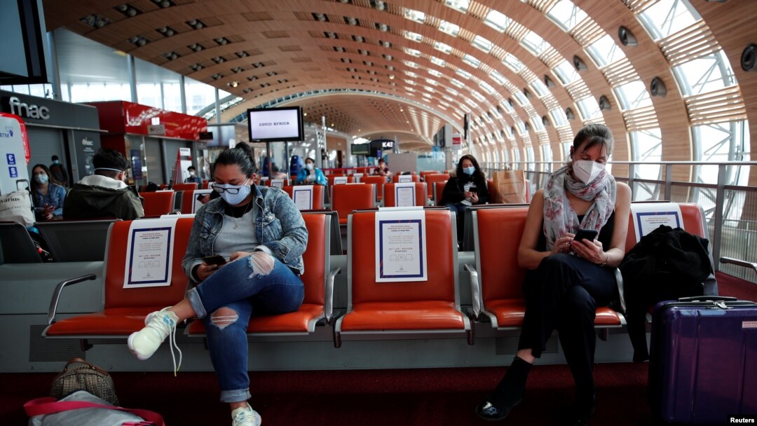 Para penumpang mengenakan masker menunggu giliran masuk ke pesawat Air France untuk penerbangan ke Mexico City di Terminal 2E Bandara Charles de Gaule, Paris, di tengah pandemi virus corona, di Perancis, 6 Mei 2020. (Foto: Benoit Tessier/Reuters)