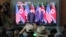 FILE - People watch a TV screen showing U.S. President Donald Trump, right, meeting with North Korean leader Kim Jong Un in Singapore during a news program at the Seoul Railway Station in Seoul, South Korea, June 12, 2018.