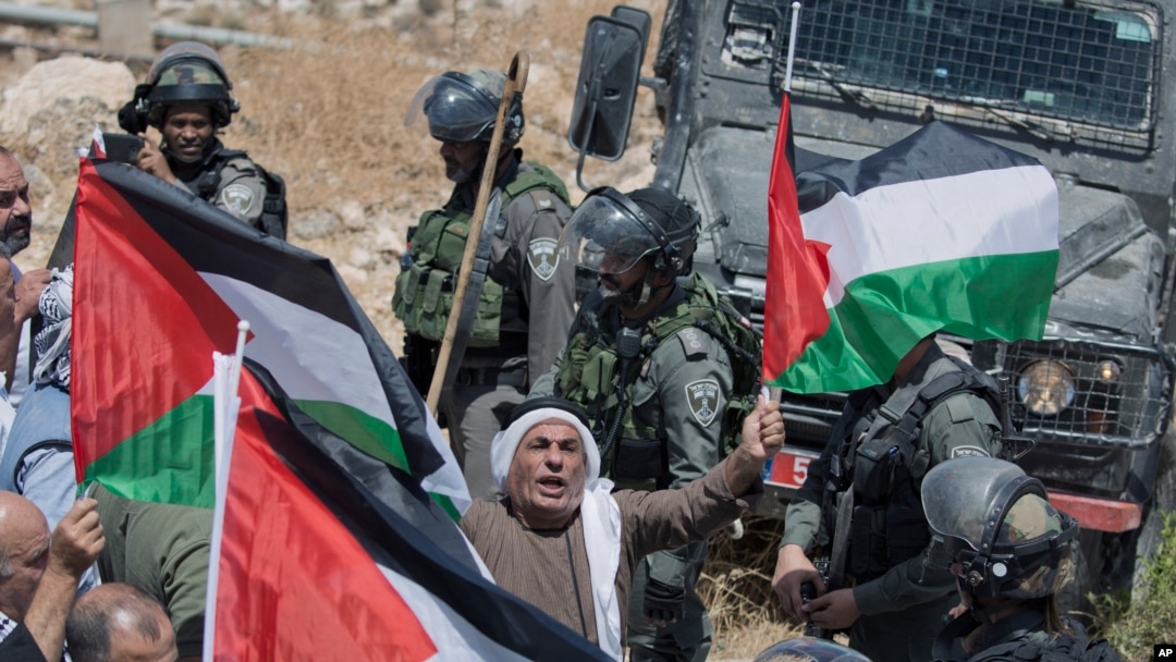 Israeli border police block the road and disperse Palestinian, Israeli and foreign activists during a rally protesting a newly established settlement near the West Bank village of Kufr Malik, East of Ramallah, Aug. 16, 2019.