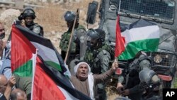 Israeli border police block the road and disperse Palestinian, Israeli and foreign activists during a rally protesting a newly established settlement near the West Bank village of Kufr Malik, East of Ramallah, Aug. 16, 2019.