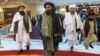 FILE - Deputy chief for Taliban political affairs, Mullah Abdul Ghani Baradar, center, arrives with other members of the Taliban delegation for a peace conference in Moscow, Russia, March 18, 2021.