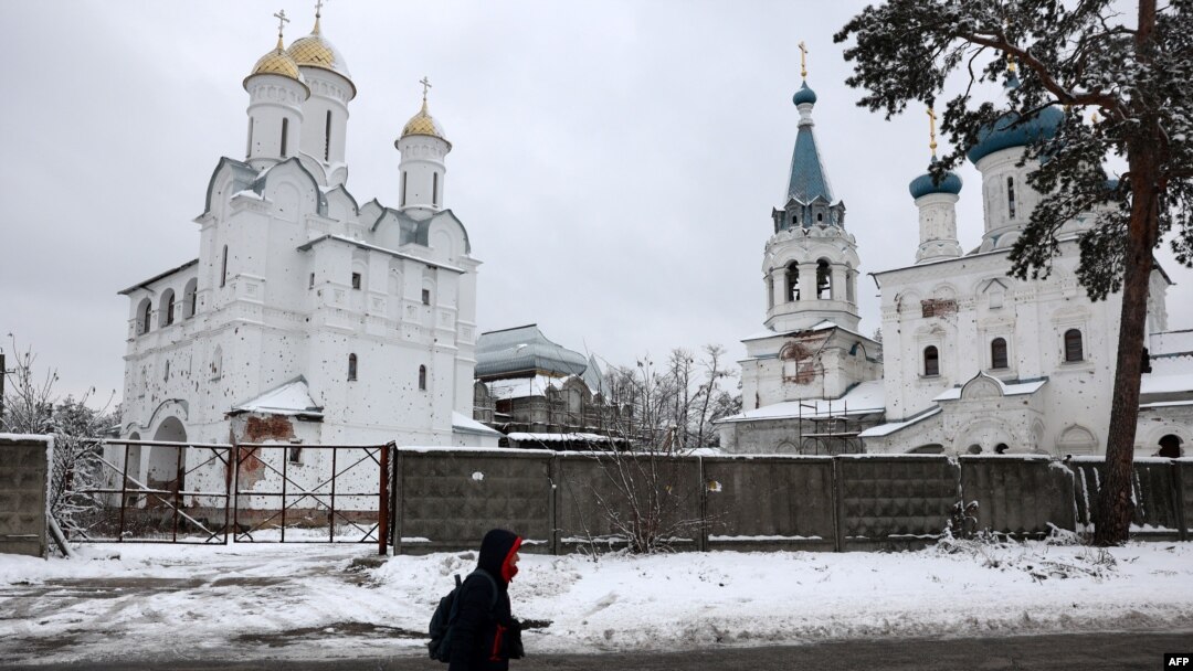 Una persona pasa junto a un monasterio dañado en Svyatohirsk, región de Donetsk, el 21 de noviembre de 2023, en medio de la invasión rusa de Ucrania.