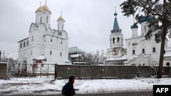 Una persona pasa junto a un monasterio dañado en Svyatohirsk, región de Donetsk, el 21 de noviembre de 2023, en medio de la invasión rusa de Ucrania.