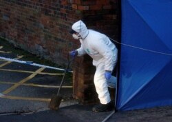 A forensics officer walks outside a property being searched in connection with a stabbing on London Bridge, in Stafford, England, Nov. 30, 2019.