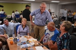 Australian Prime Minister Scott Morrison (L) speaks to residents at an evacuation center in Taree, 350km north of Sydney on Nov. 10, 2019.