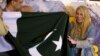 FILE - British-American mountaineer Vanessa O'Brien, right, who holds the Guinness World Record for climbing the Seven Summits in 295 days, receives Pakistani flag from officials during her news conference in Islamabad, Pakistan, June 15, 2017. 