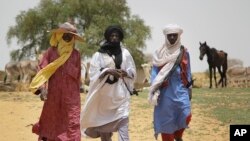 FILE-In this file photo taken July 22, 2012, Peul and Tuareg herdsmen walk to the livestock market in the desert village of Sakabal, Niger, north of Maradi. Niger has suffered extremist attacks for years — including Boko Haram suicide bombers from Nigeria.