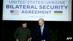 Presiden Ukraina Volodymyr Zelensky (kiri) dan Presiden AS Joe Biden menandatangani perjanjian keamanan bilateral selama konferensi pers di Masseria San Domenico di sela-sela KTT G7 di wilayah Apulia, Italia, Kamis (13/6). 