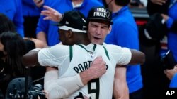 The Milwaukee Bucks' Brook Lopez, right, hugs Bobby Portis after defeating the Atlanta Hawks in Game 6 of the Eastern Conference finals in the NBA basketball playoffs and advancing to the NBA Championship, July 3, 2021, in Atlanta. 