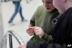 Brentley Joyce, 8, and Hunter Kimbel, 7, look at a souvenir penny from a penny press machine at the American Dream Mall, March 2, 2025, in East Rutherford, N.J.