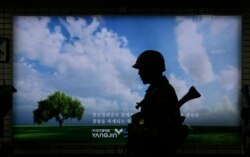 FILE - A South Korean army soldier passes by an advertising board during an anti-terror drill as part of Ulchi Freedom Guardian exercise, at Sadang Subway Station in Seoul, South Korea, Aug. 19, 2015.