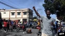 Demonstrators march on the street near parliament as they protest against ruling government in Port-au-Prince, Sept. 23, 2019. 