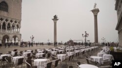 Empty tables sit in St. Mark&#39;s square in Venice, Italy. Italy has been working to slow the spread of Europe&#39;s first major outbreak of the new coronavirus. It has called off the popular Venice Carnival and closed major tourist attractions.