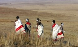 FILE - Youths walk in a field outside an initiation school in the Eastern Cape, South Africa, July 10, 2006.