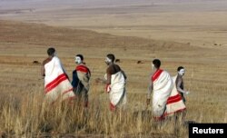 FILE - Youths walk in a field outside an initiation school in the Eastern Cape, South Africa, July 10, 2006.