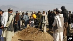 Un hombre afgano pone agua sobre la tumba de Mohammad Sami, de 21 años, quien resultó muerto el miércoles, 9 de diciembre de 2015, en el ataque al aeropuerto de Kandhar, Afganistán.